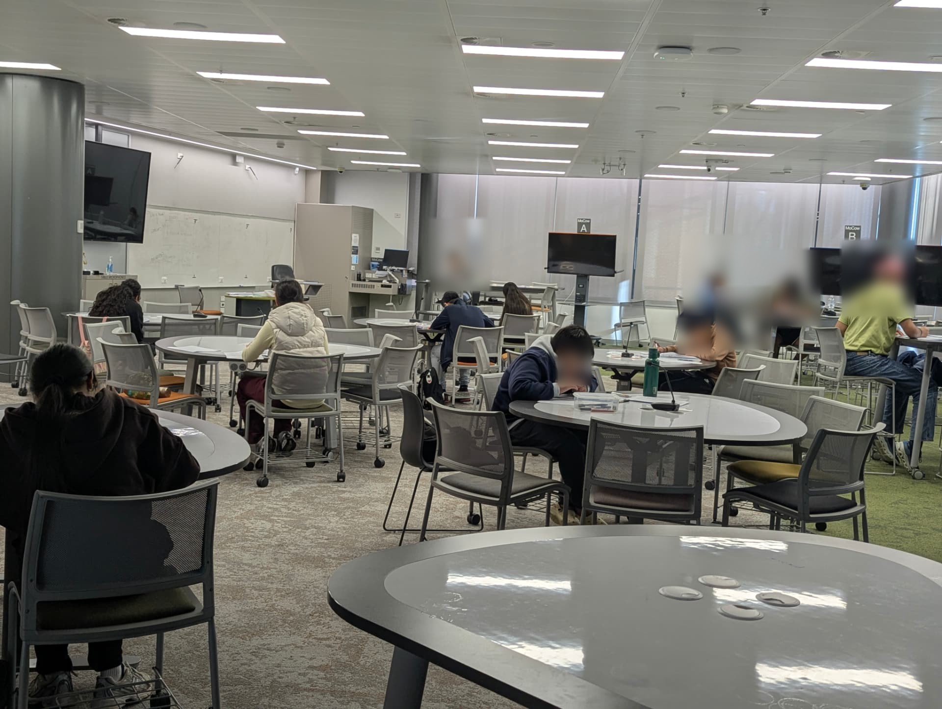 Students sitting a timed EduPrism trial examination in a library hall
